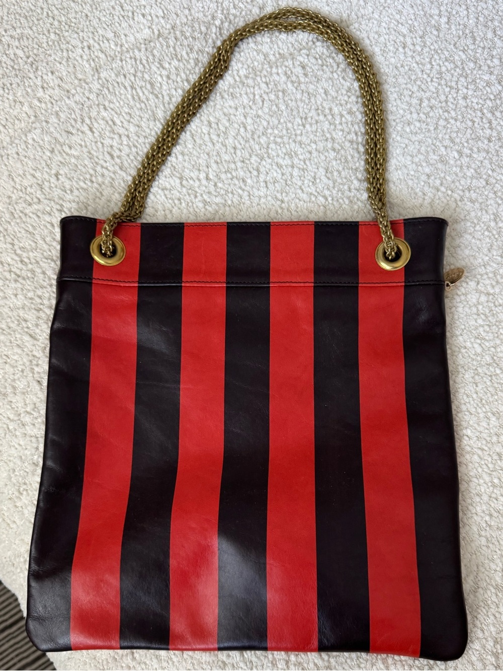 Clare V Delphine shoulder bag in red and burgundy stripe with gold metal straps.